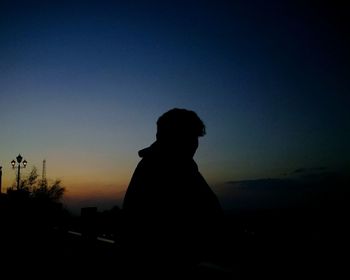 Silhouette man looking at sunset