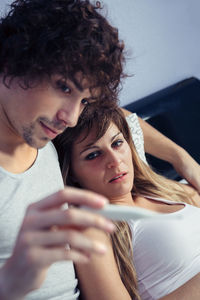 Close-up of young woman using mobile phone at home