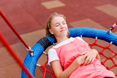 High angle view of girl and rope against blue wall