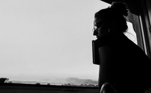 Side view of woman standing against sky