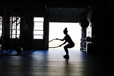 Silhouette woman exercising with rope