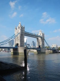 Tower bridge over thames river against sky in city