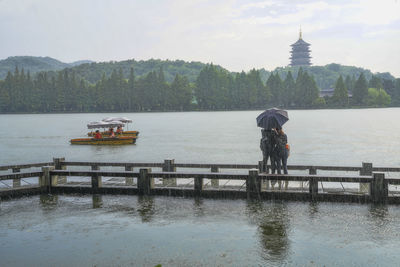 People sailing on river against sky