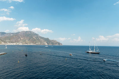 Sailboats sailing in sea against sky