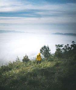 Full length of hiker walking on mountain against sky