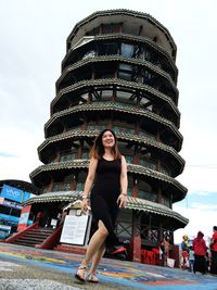 Smiling woman standing against building in city