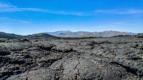 Scenic view of dramatic landscape against blue sky