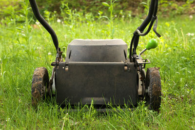 Low angle close-up lawn mower ready to cut long grass or concept of avoiding to help bee population