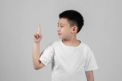 Boy looking away against white background