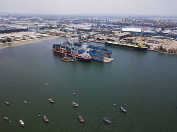 Aerial logistics commercial vehicles waiting to be load on to a car carrier ship at dockyard