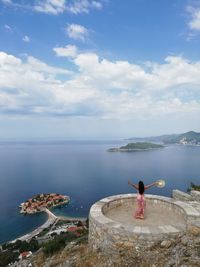 Rear view of people looking at sea against sky