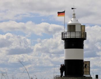 Lighthouse by sea against sky