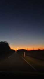 Car on road against sky at sunset