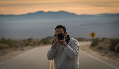 Man photographing on road