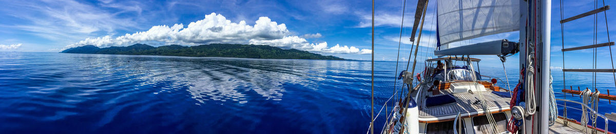 Sailboats sailing in sea against sky