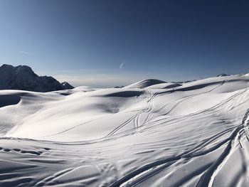 Scenic view of snowcapped mountains against clear blue sky