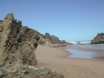 Scenic view of beach against clear blue sky