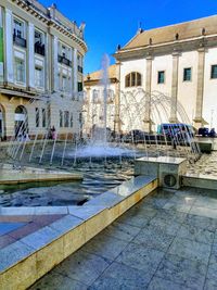 Fountain by building in city