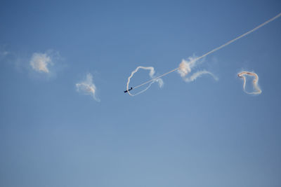 Low angle view of vapor trail against blue sky