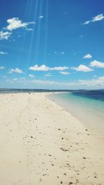 Scenic view of beach against blue sky