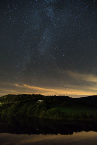 Scenic view of landscape against star field at night