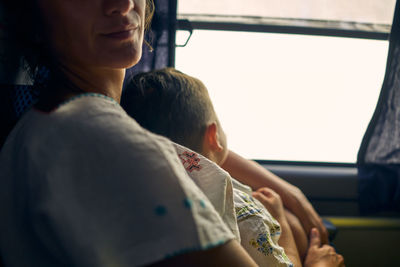 Midsection of mother and boy in public bus in méxico 