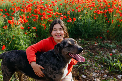 Portrait of young woman with dogs on field