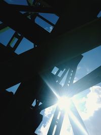 Low angle view of sunlight streaming through silhouette building