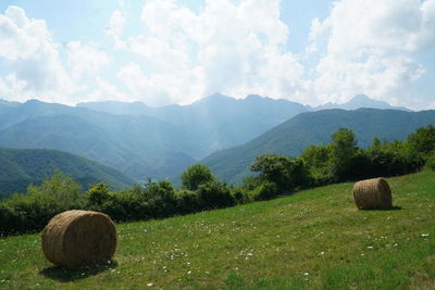 Hay bales on field against sky