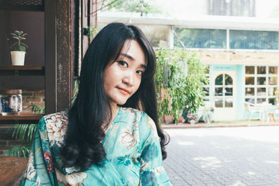 Portrait of beautiful young woman standing outdoors