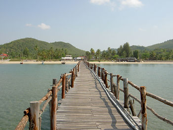 Pier over calm lake against sky