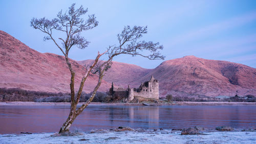 Sunrise on frosty winter morning with reflections of kilchurn castle in loch awe, highlands scotland