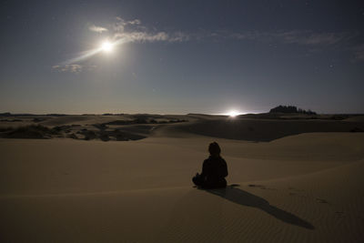 Woman in meditation at night, oregon dunes.