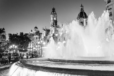 Panoramic view of fountain against buildings in city