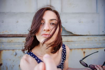 Portrait of beautiful woman against wall