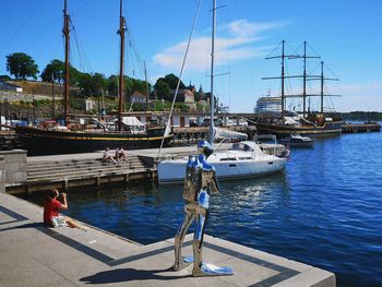 Sailboats moored at harbor