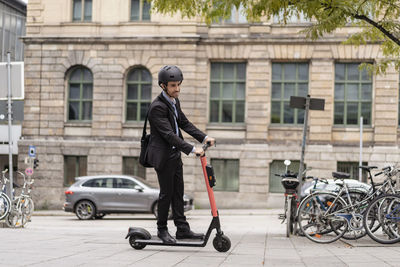 Businessman riding e-scooter in the city