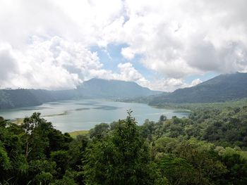 Scenic view of mountains and lake against cloudy sky