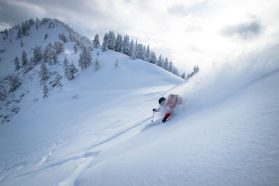 People skiing on snowcapped mountain against sky