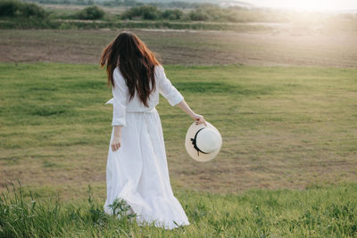 Rear view of woman standing on field