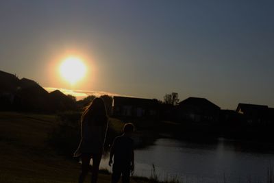 Silhouette woman standing against clear sky during sunset