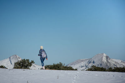 Woman walking on snow covered mountain