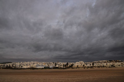 City by sea against storm clouds