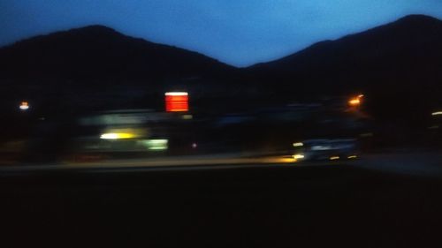 Blurred motion of cars on road against sky at night