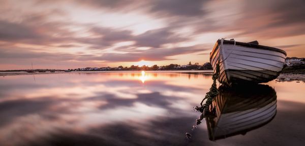 Reflection of moored boat in calm sea