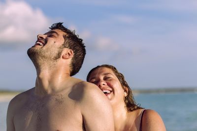 Portrait of a smiling young couple against sky