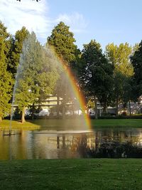 Scenic view of rainbow over fountain against sky