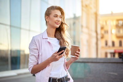 Young woman using mobile phone in city
