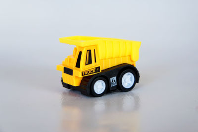 Close-up of yellow toy car against white background