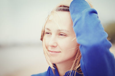 Close-up of woman with tousled hair standing outdoors